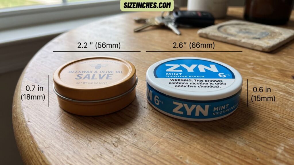 A round lip balm tin next to a Zyn can showing a similar flat round shape