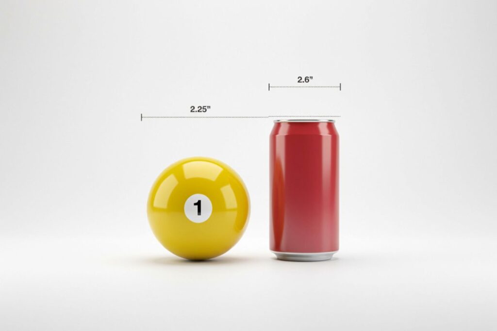 Billiard ball compared to a Coke can to picture the width of a soda can