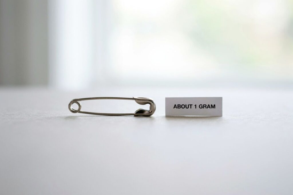 A small safety pin weighing about 0.5 to 1 gram shown as a light weight reference
